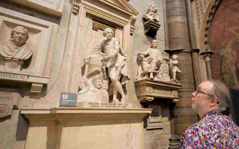 Photograph of member of staff looking at Shakespeare memorial within Poets' Corner