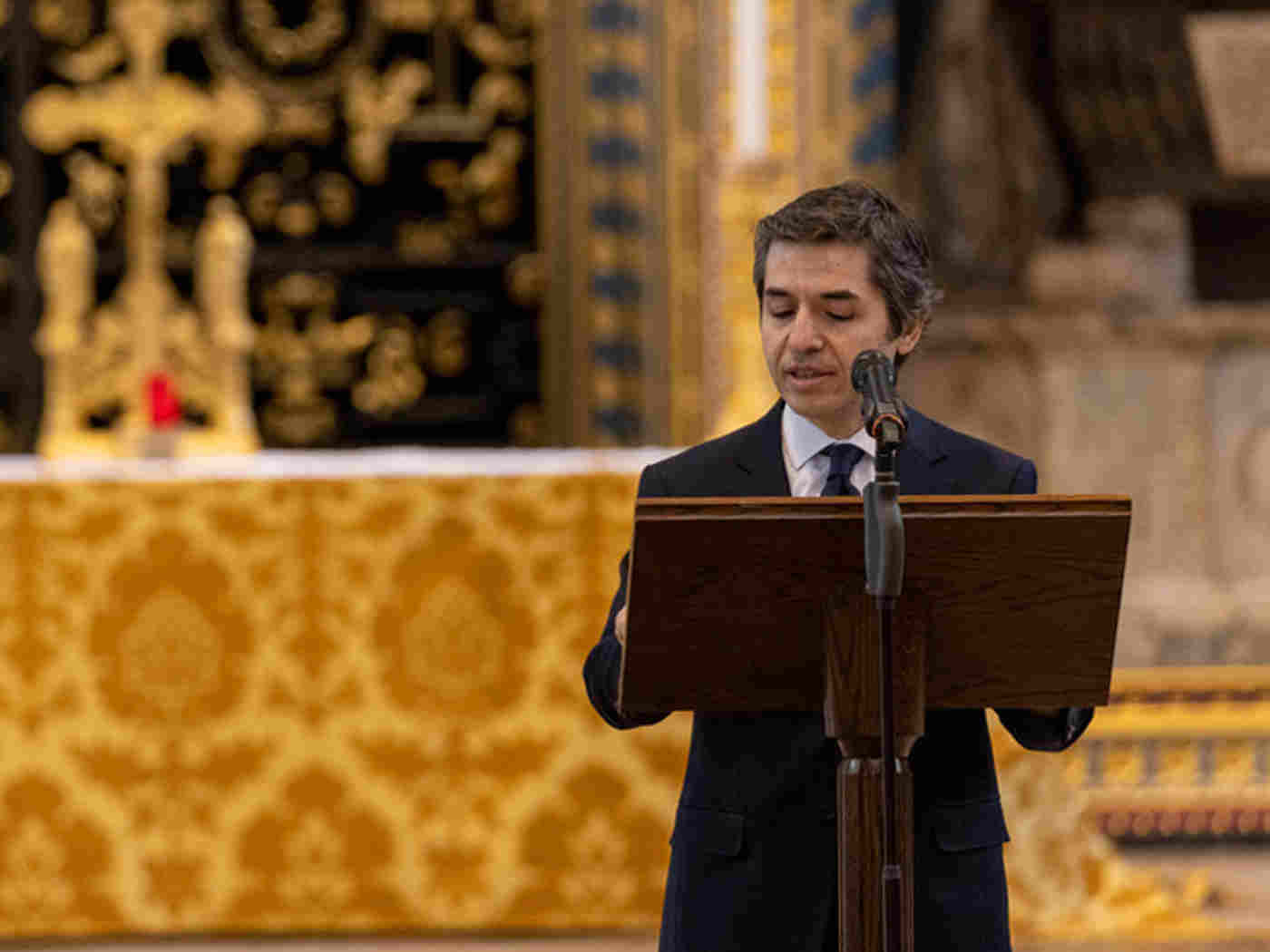 Turkish High Commissioner Osman Koray Erta reads from a podium