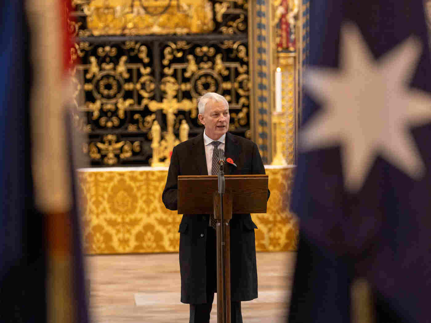 New Zealand High Commissioner Phil Goff reads from a podium