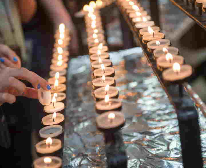 Photograph of person lighting a candle at Westminster Abbey