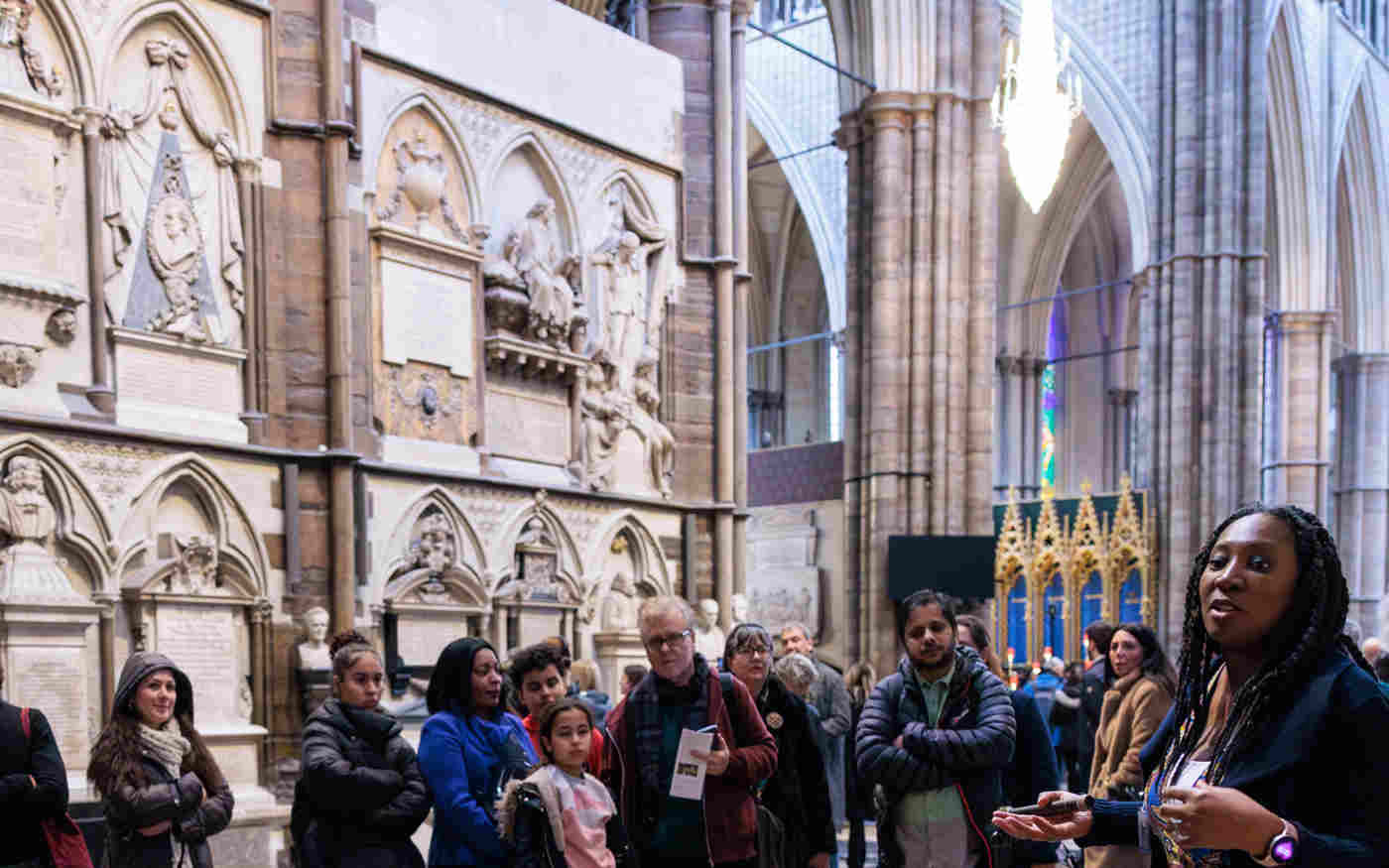 Photograph of members of the general public listening to a tour guide within Poets' Corner of Westminster Abbey