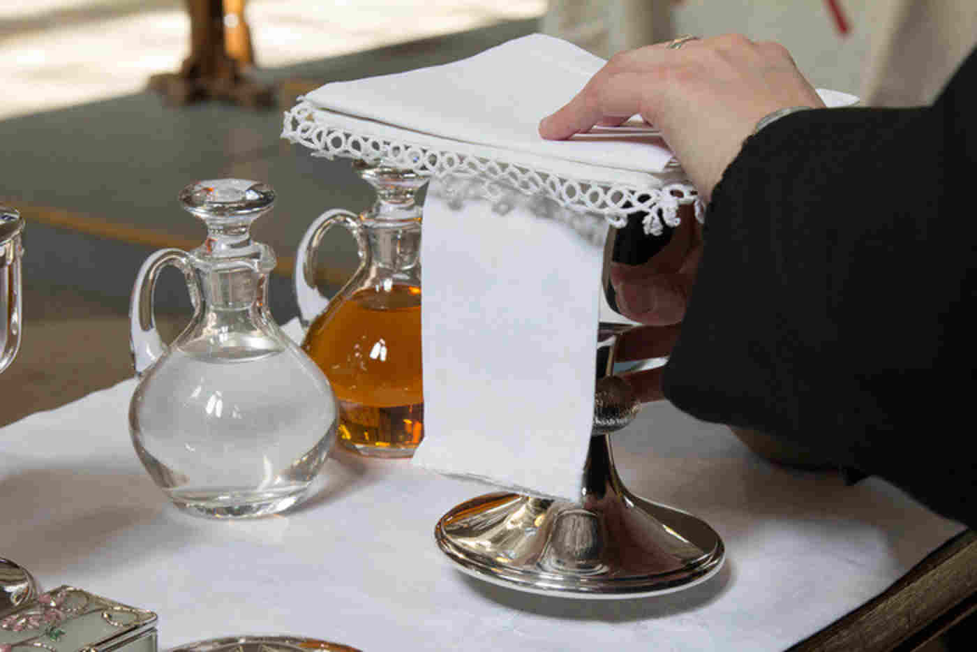 Glass jugs of water and wine with a silver chalice