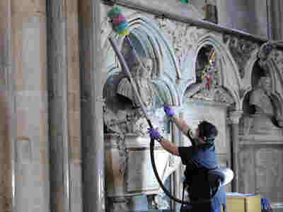 Photograph of heritage cleaners working on the fabric of the building within Westminster Abbey