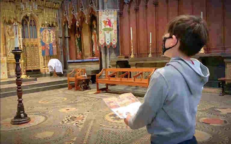 Photograph of child wearing a mask looking at the Cosmati Pavement in Westminster Abbey