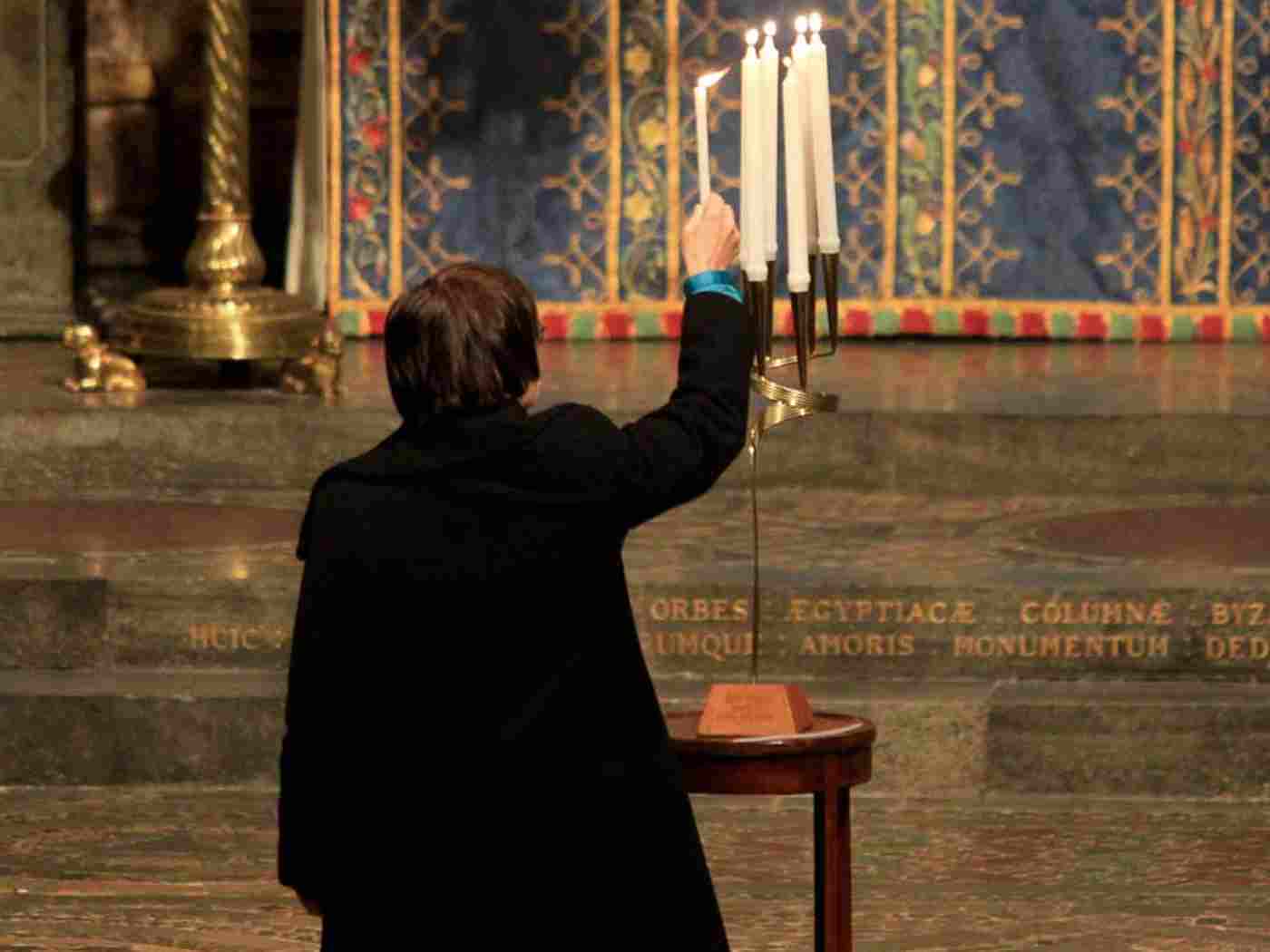 Julia Gross, representing the German Ambassador, lights a memorial candle