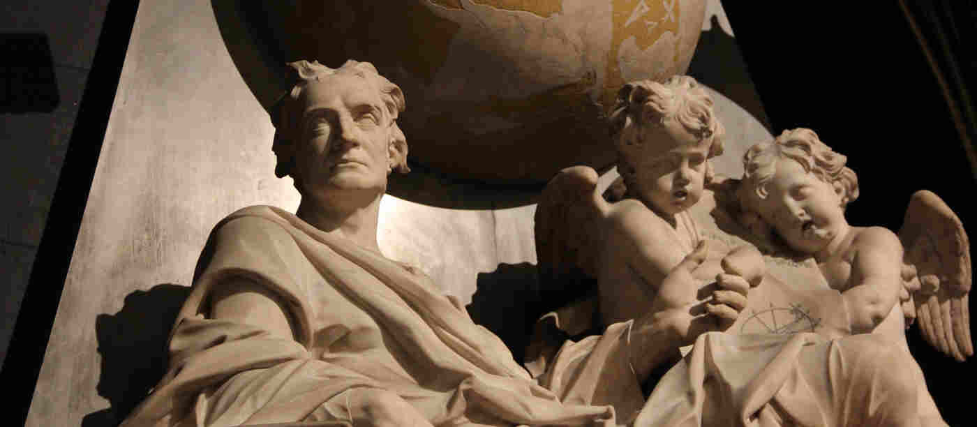 Close-up photography of Sir Isaac Newton memorial, including a globe and two cherubs, within Scientists' Corner in Westminster Abbey