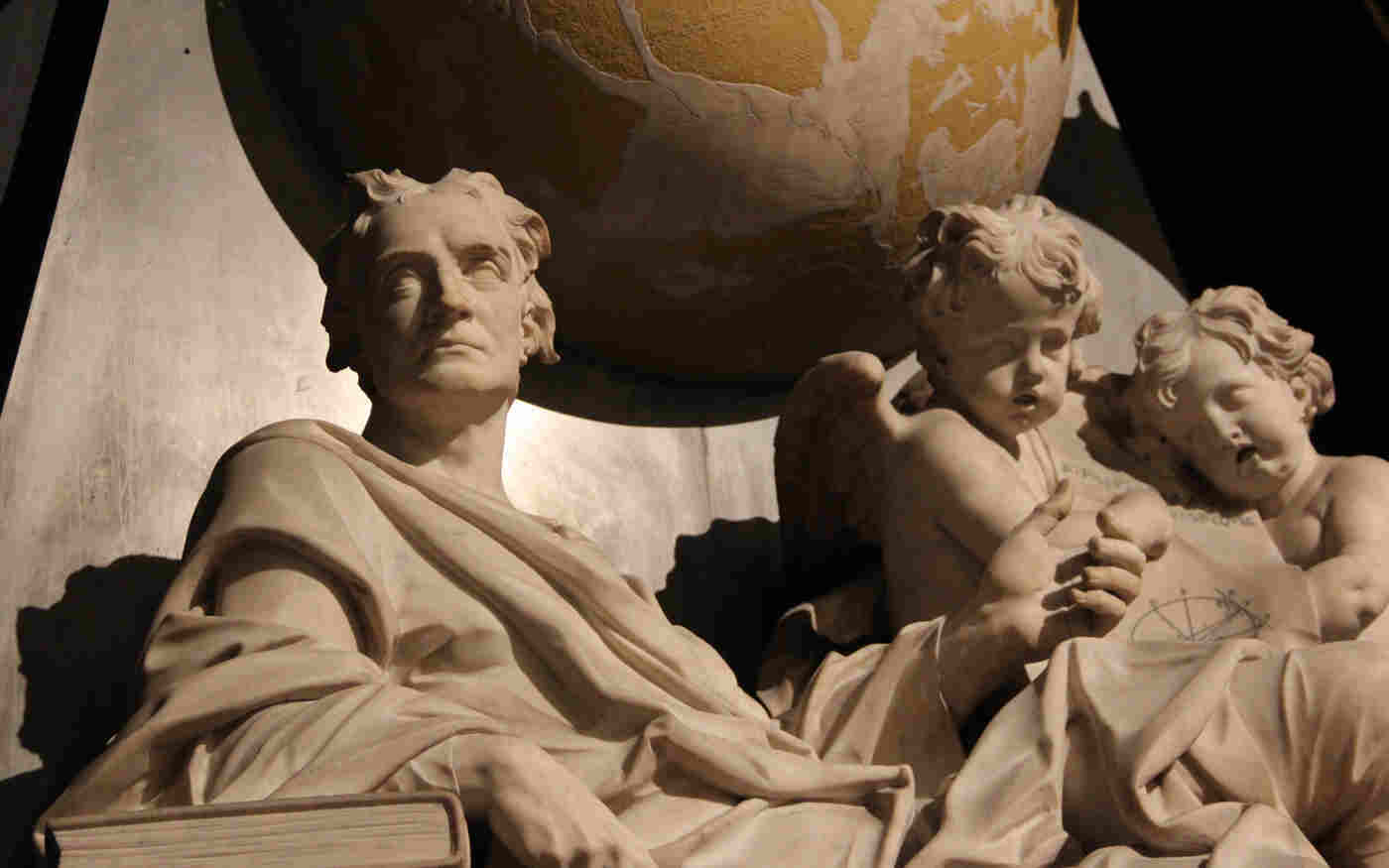 Close-up photography of Sir Isaac Newton memorial, including a globe and two cherubs, within Scientists' Corner in Westminster Abbey