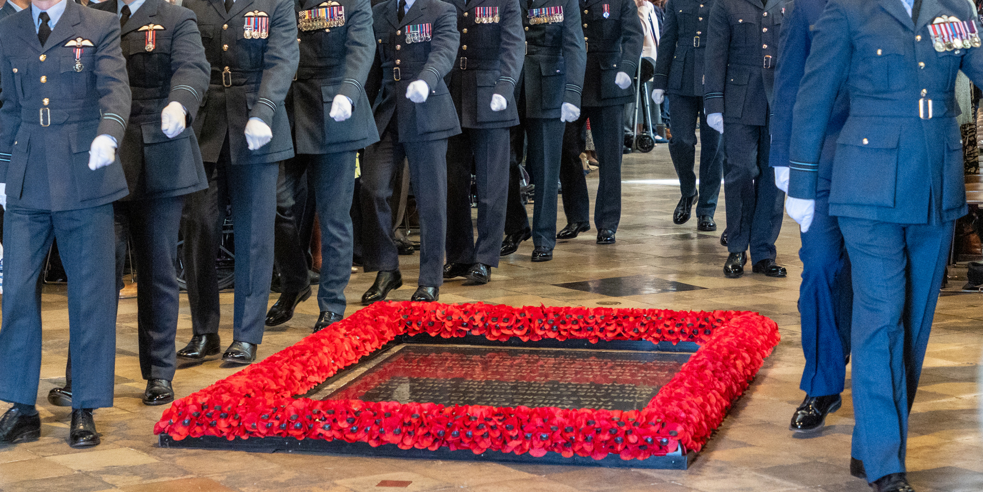 A formal wreath-laying ceremony inside Westminster Abbey, with uniformed Royal Air Force personnel standing around the Grave of the Unknown Warrior