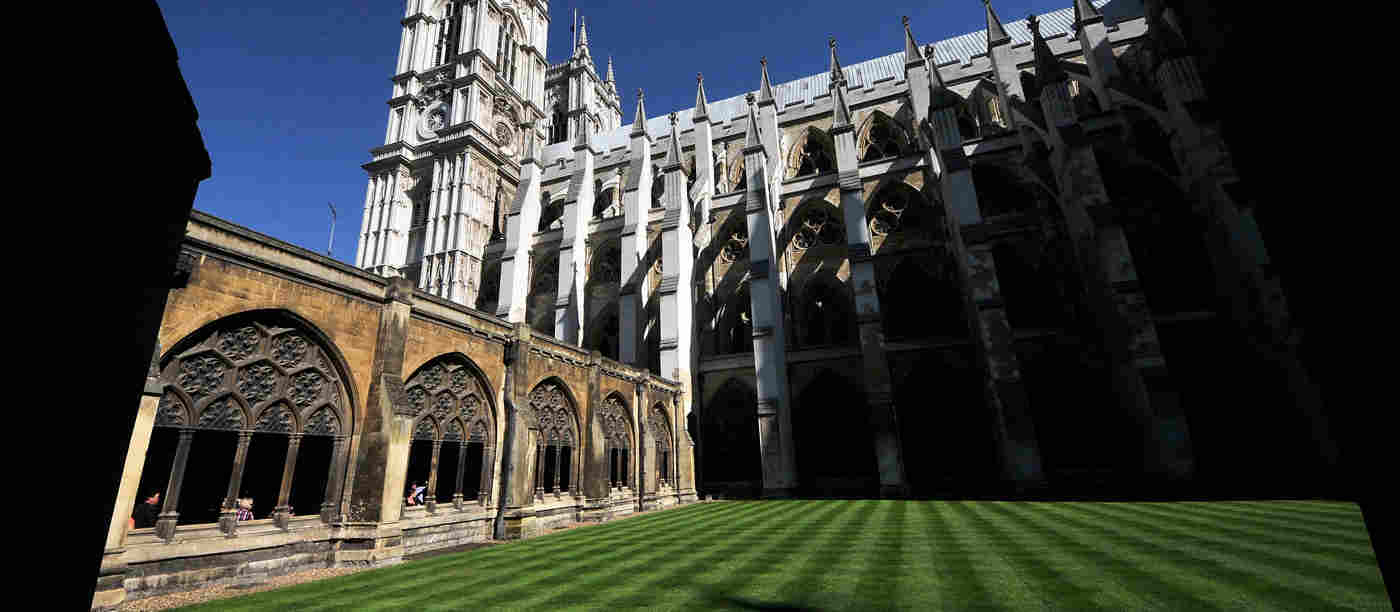 Photograph of the empty garth within Westminster Abbey, with freshly mowed lawn in a mixture of sunshine and shadow
