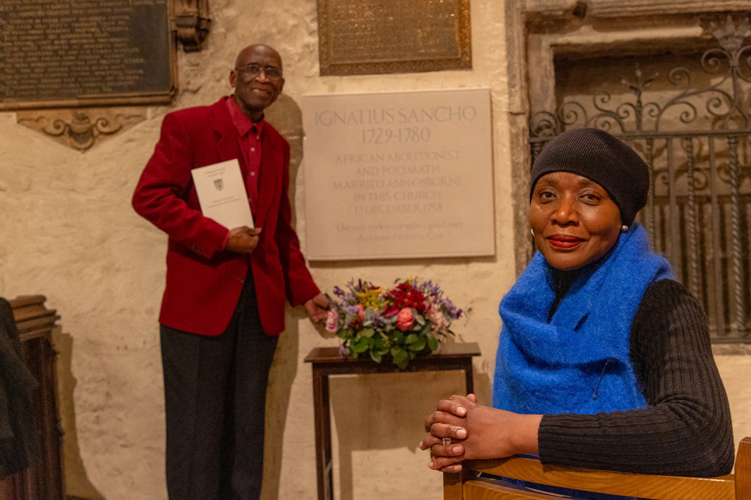 Arthur Torrington next to a memorial stone for Ignatius Sancho and Ann Osbourne. The sculptor Marcia Bennett-Male is in the foreground