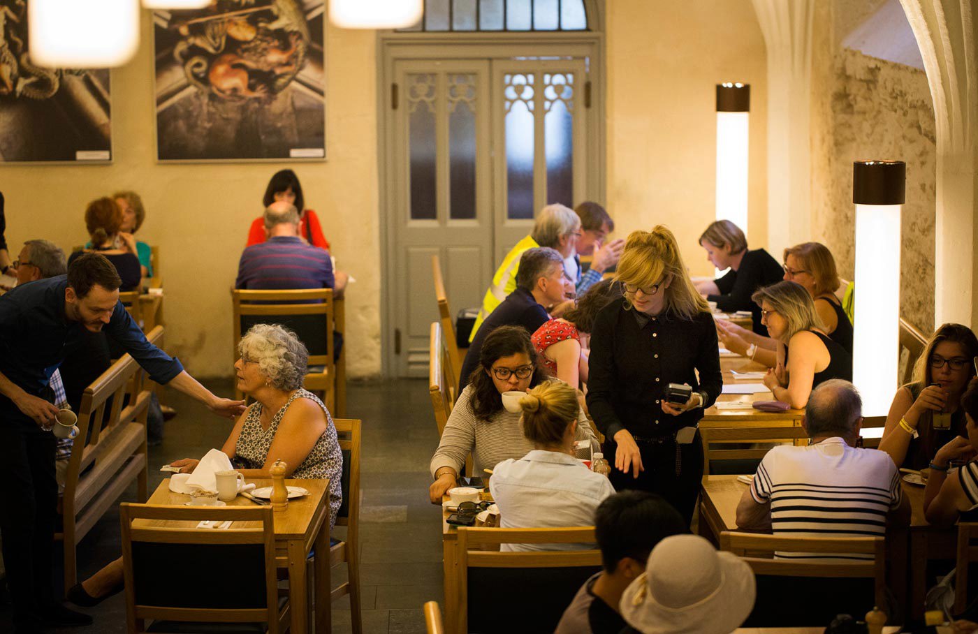 Waiters serve customers seated at tables in the Cellarium Cafe, Westminster Abbey