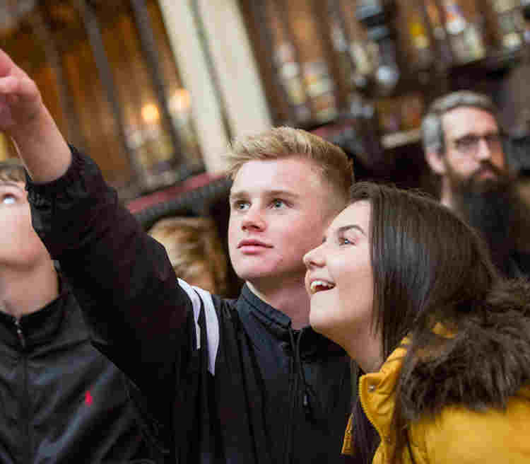 A group of students from overseas tour point out details in Westminster Abbey