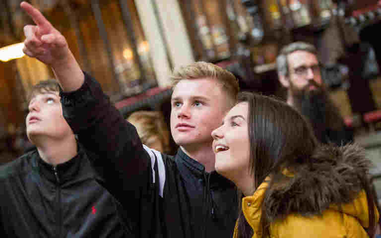 A group of students from overseas tour point out details in Westminster Abbey
