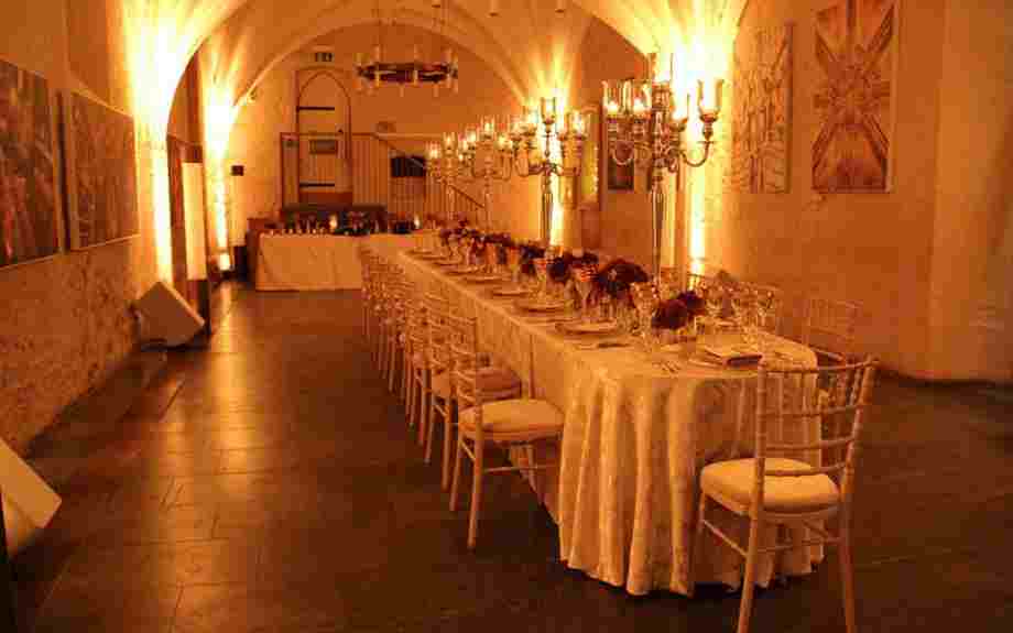 A long table set for a formal corporate dinner in the Cellarium, Westminster Abbey