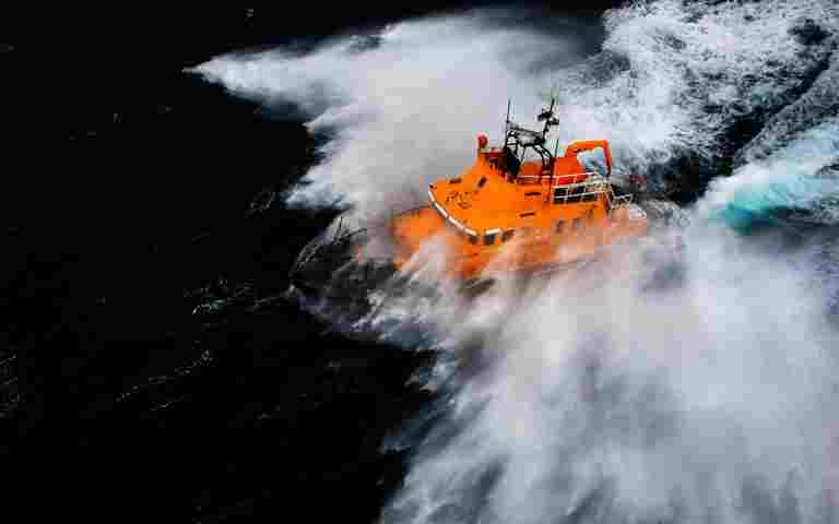 An orange boat in choppy waters