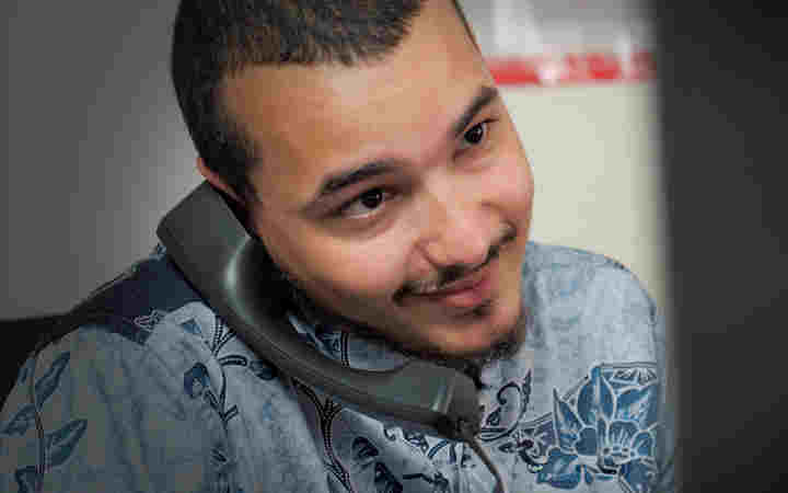 Photograph of male employee smiling while on the phone within a Westminster Abbey office