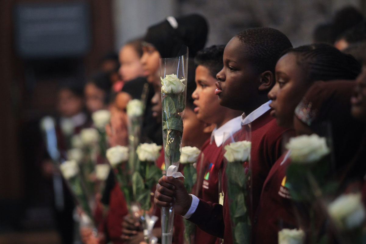 Children from Webster Primary School, Moss Side, received white roses from survivors of the Holocaust