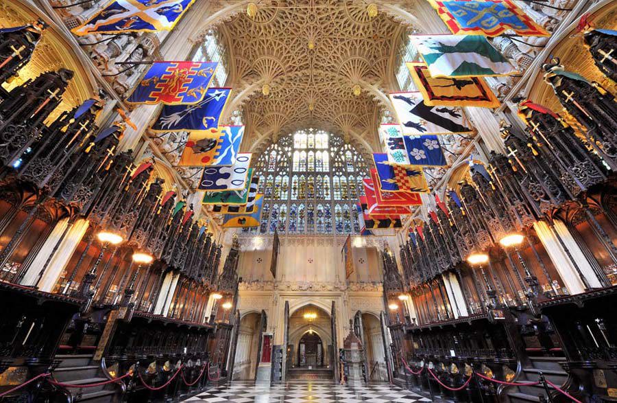 The colourful flags of the Knights of the Order Bath hanging above the wooden stalls in the Lady Chapel, Westminster Abbey