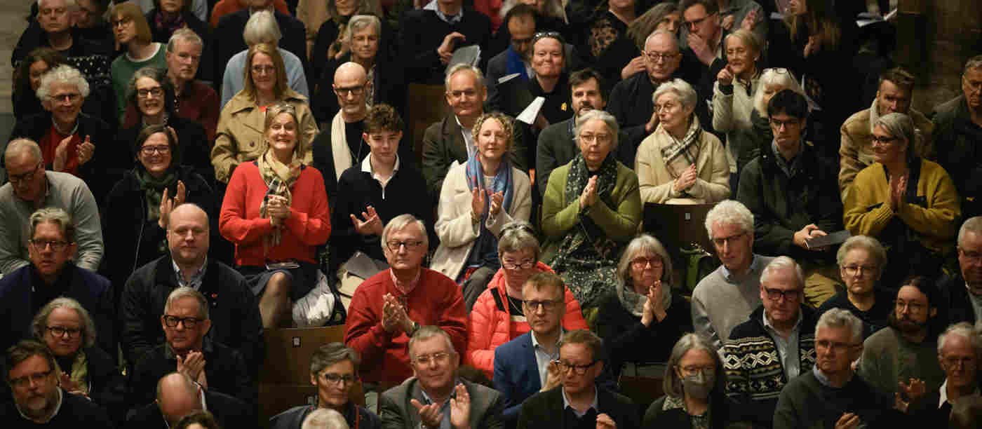 A front-facing photograph of a whole crowd of visitors listening to a talk