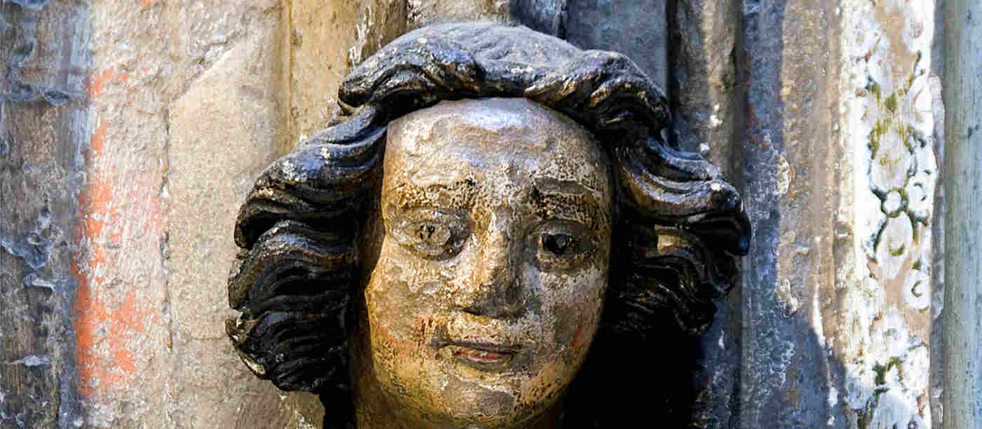 Close-up photograph of a female stone head carving within Westminster Abbey