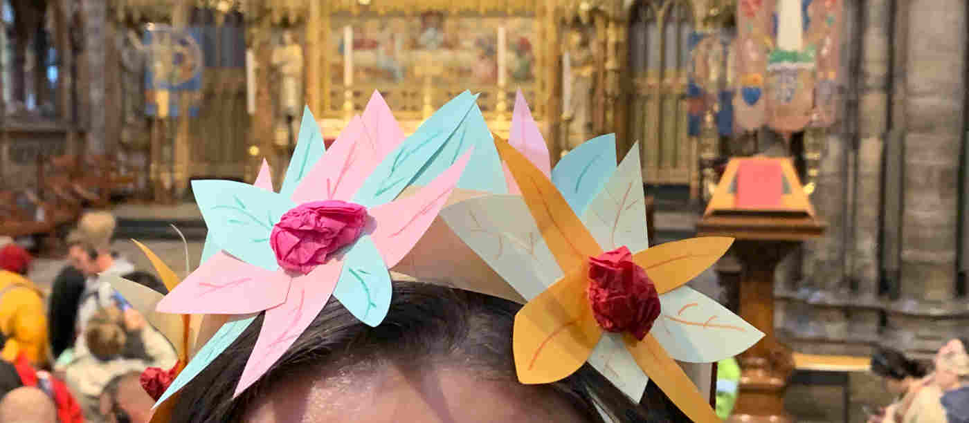 Photograph of nature crown on a person's head in front of the High Altar, a craft activity at Westminster Abbey
