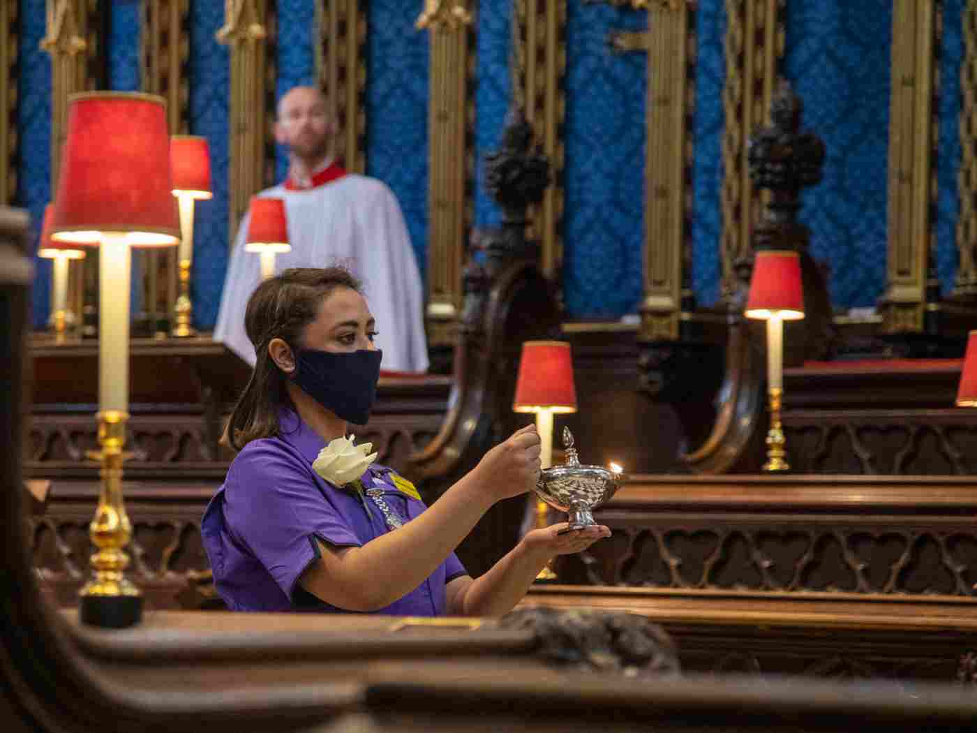 The lamp is carried through the Abbey by Ruheana Begum, a Matron at a London hospital