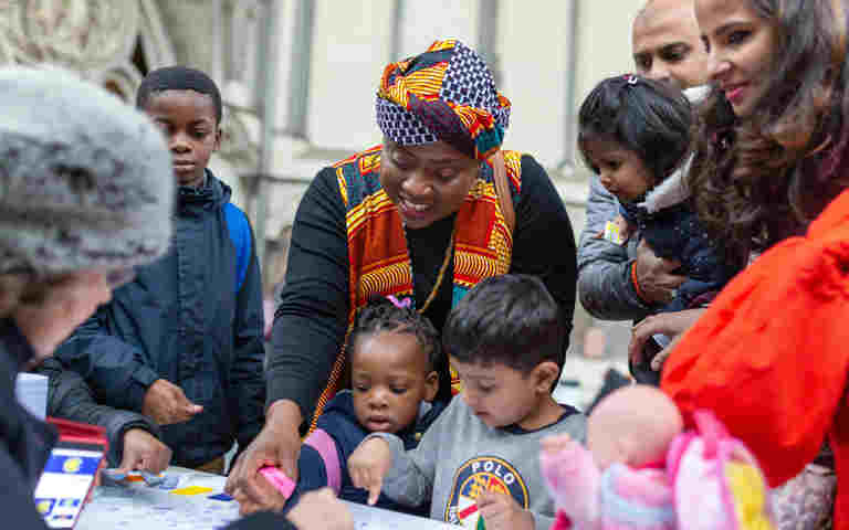 Photograph of multiple families, with adults and children, taking part in activities