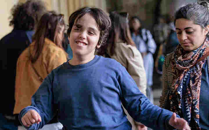 Photograph of child walking through the cloisters, with other visitors in the background