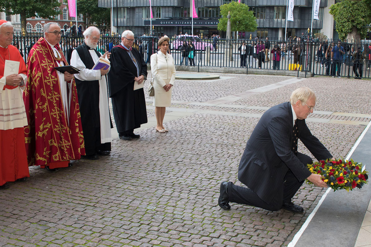 Julian Filochowski, Chair, Archbishop Romero Trust, lays a wreath beneath the statue of Blessed Oscar Romero’s on the West front of the Abbey Church
