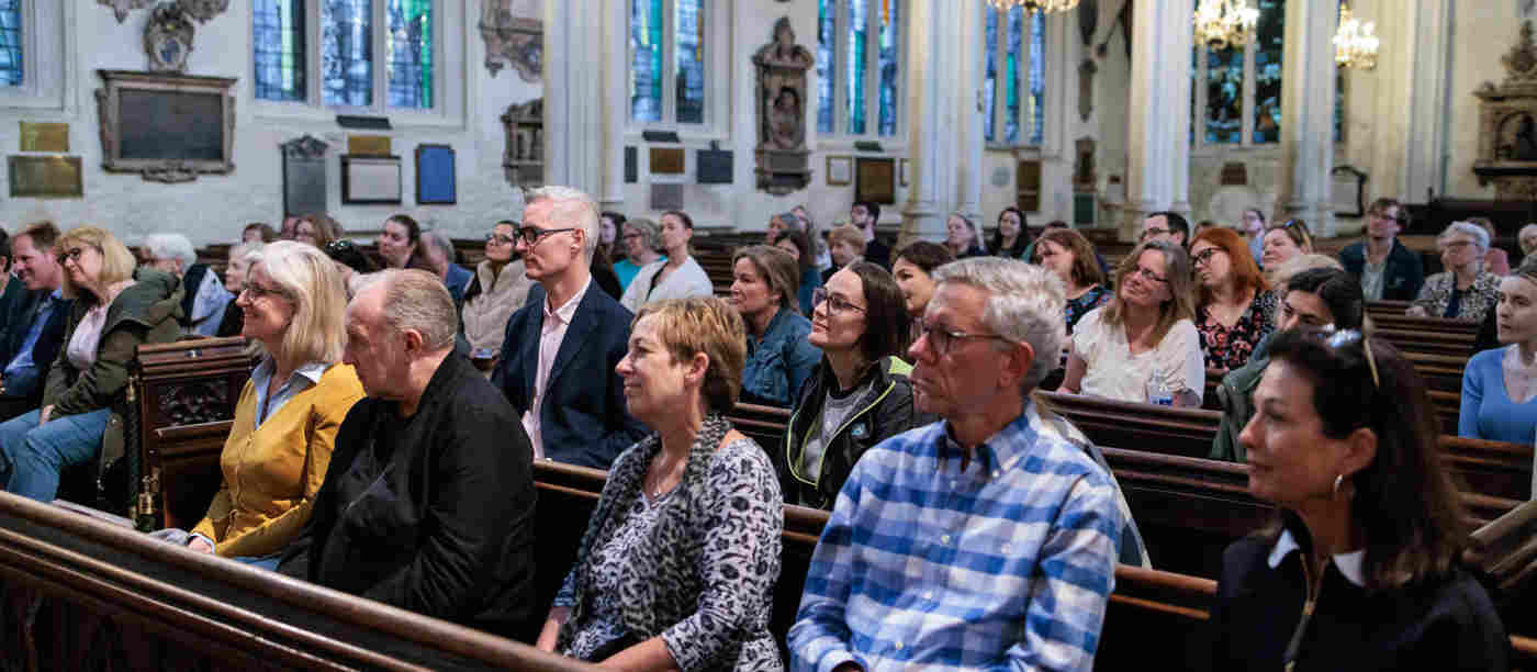 Photograph of lots of people sitting in the pews as audience members for a talk within St Margaret's Church