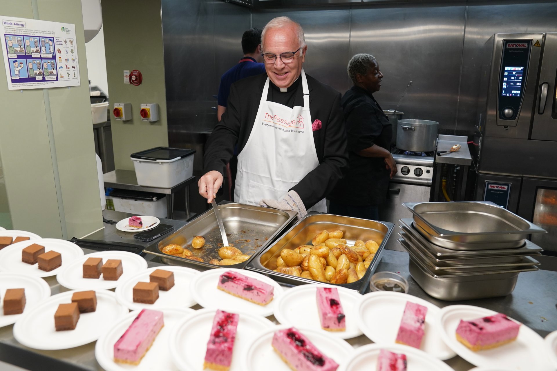 The Dean of Westminster, David Hoyle wearing an apron and serving potatoes
