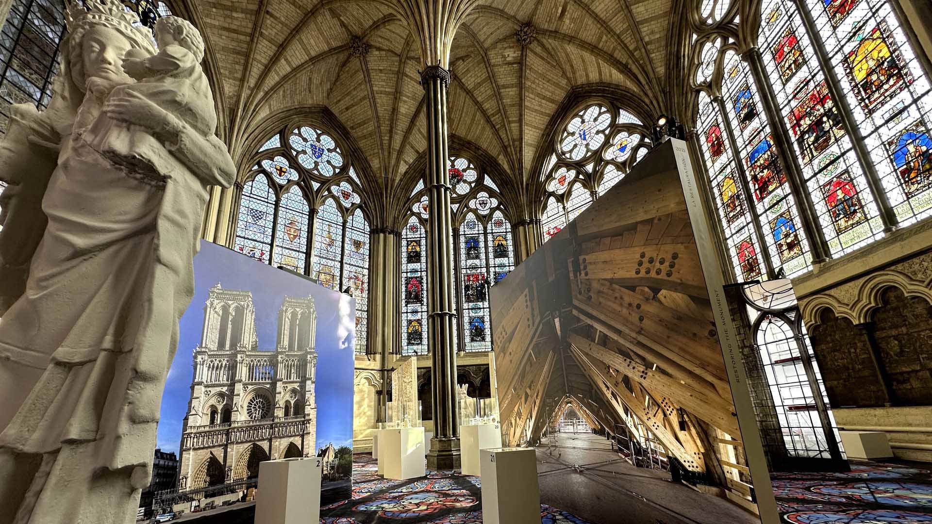 A statue with paintings around it and stained glass in the background