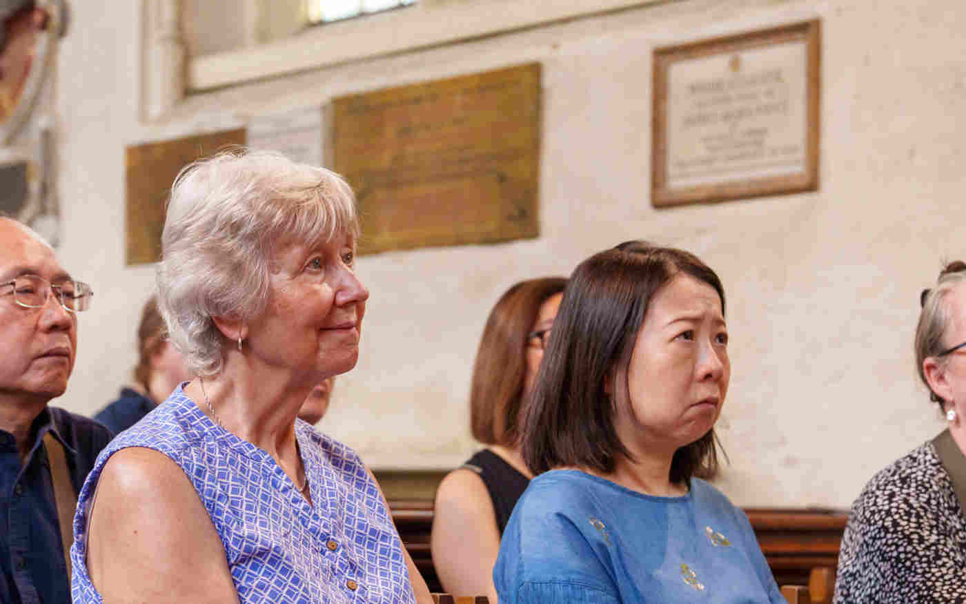 Photograph of a group of visitors sitting listening to a talk within St Margaret's Church, Westminster Abbey